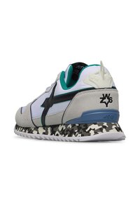 Sneaker con parte superiore in suede grigio e sintetico bianco, accenti neri, rifiniture teal e una suola con stampa camo testurizzata. Presenta un'etichetta sul tallone in rilievo.