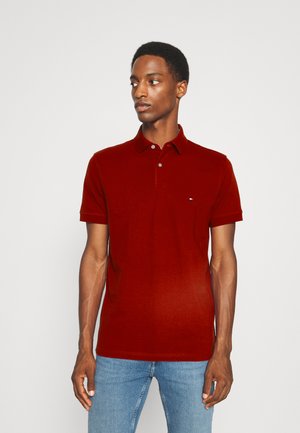 Bordeauxkleurig poloshirt met een kraag, drie knoopsluitingen en een klein logo op de linker borst. Gemaakt van een soepele katoenmix.