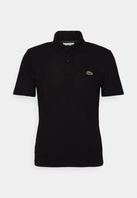 Svart polo t-shirt i bomull, med klassisk krage, två knappar och en liten grön och vit broderad krokodillogga på bröstet.