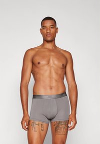 Hallid bokserpüksid veniva kangaga, millel on sile vöökoht ja keha jälgiv lõige. Ilma mustrite või nähtava riistvarata.