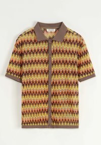 Chemise à manches courtes avec un motif zigzag multicolore en orange, jaune et marron, avec un col et des boutons marron.
