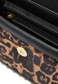 Borsa nera con stampa leopardata e accessori dorati, dotata di molteplici scomparti e superficie testurizzata. Chiusura a scatto magnetico.