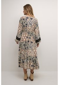 Robe maxi à manches longues, imprimé floral et cachemire dans des teintes de bleu, vert et beige. Présente un ourlet volanté et des accents en dentelle.