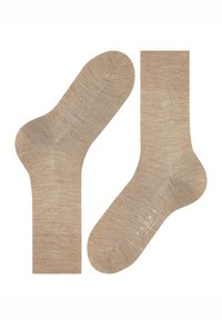Calcetines beige confeccionados con tela texturizada, con punta sin costuras y puño acanalado. Logotipo destacado impreso en el lateral.