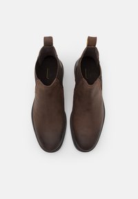 Braune Leder-Ankle-Boots mit elastischen Seitenpanels, runder Zehenpartie und Zuglasche an der Ferse. Sie zeichnen sich durch eine glatte Textur und ein zurückhaltendes Design aus.