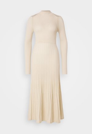 Rochie cu mânecă lungă, din tricot cu nervuri, de culoare bej deschis, cu un corsaj ajustat și o fustă evazată, dotată cu pliseuri verticale și un gât tip mock.