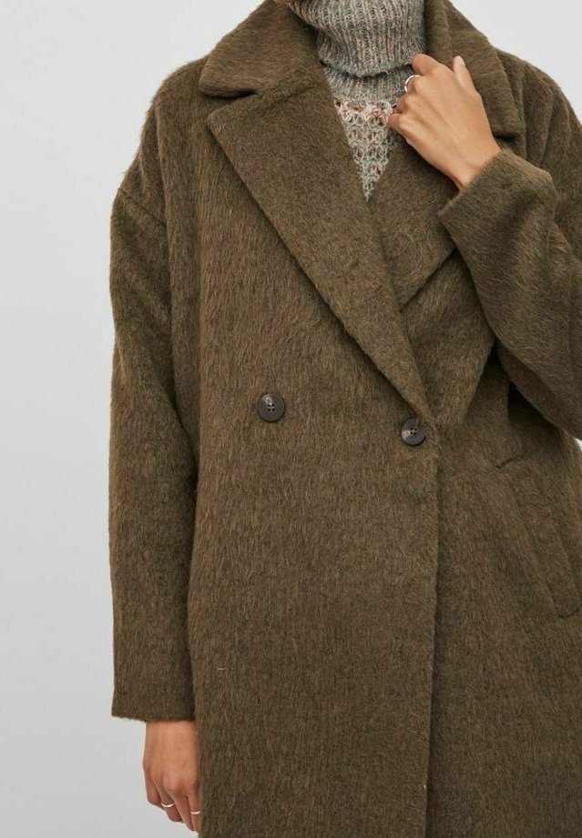 Olivově zelený dvouřadý kabát z texturované, chlupaté látky s velkými klopami a dvěma předními kapsami, zapínáním na knoflíky a volným střihem.
