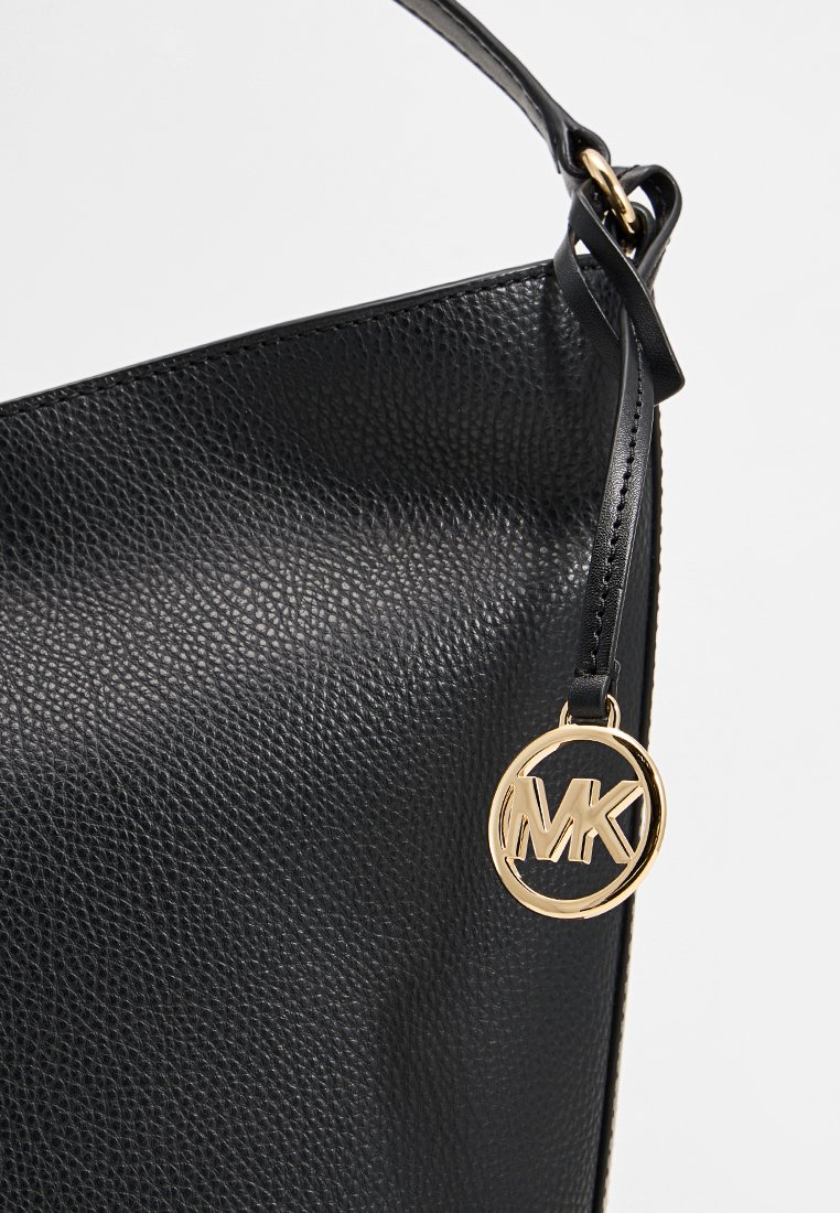 Borsa tote nera in pelle testurizzata con una forma strutturata, caratterizzata da un pendente circolare in oro e una tracolla regolabile elegante.