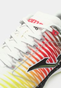 Bijela sportska cipela s bijelim vezicama, gradijentnim prugama u crvenoj, narančastoj i žutoj boji te crnim logotipom u obliku strelice sa strane.