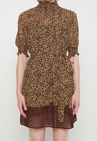 Vestido de estampado de leopardo con un alto escote fruncido, mangas cortas abullonadas y una cintura ajustada. Diseño en capas con un dobladillo más oscuro.