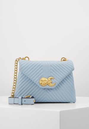 Lichtblauwe doorgestikte crossbodytas met gouden kettingriem en gouden zon- en maan gesp detail op de voorflap.