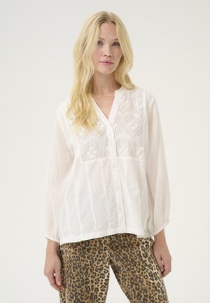 Witte, gestructureerde blouse met geborduurde bloemendetails en een knoopsluiting aan de voorkant. Voorzien van lange, licht geplooide mouwen en een ontspannen pasvorm.