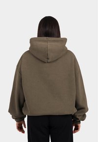 Übergroßer olivgrüner Hoodie mit Kapuze und Kordelzug, aus weichem Material gefertigt, mit überschnittenen Schultern und gerippten Bündchen.