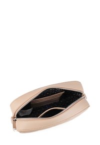 Kožená kapsa na zip v broskvové barvě, obdélníkového tvaru. Interiér podšívka z černé tkaniny s bílými tečkami; obsahuje sloty na karty a malou kapsu.