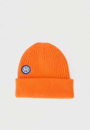 Bonnet tricoté orange avec nervures verticales, bord plié et un patch circulaire bleu avec texte blanc. Texture douce et ajustement confortable.