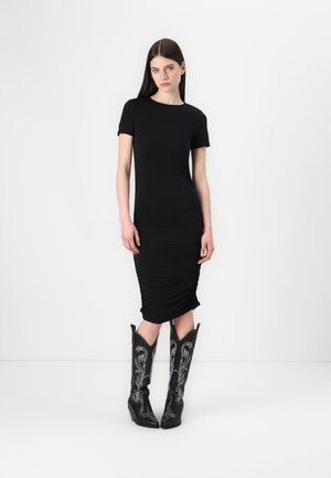 Black fitted midi dress with short sleeves and ruched detailing, paired with black cowboy boots featuring silver embroidery and pointed toes.