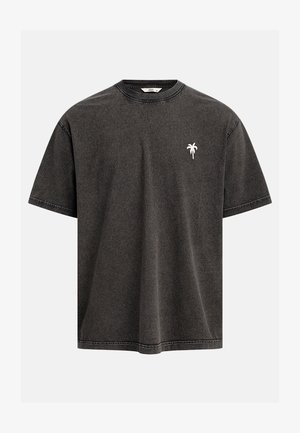 T-shirt gris charbon à manches courtes avec col rond et petite broderie blanche de palmier sur le côté gauche de la poitrine.