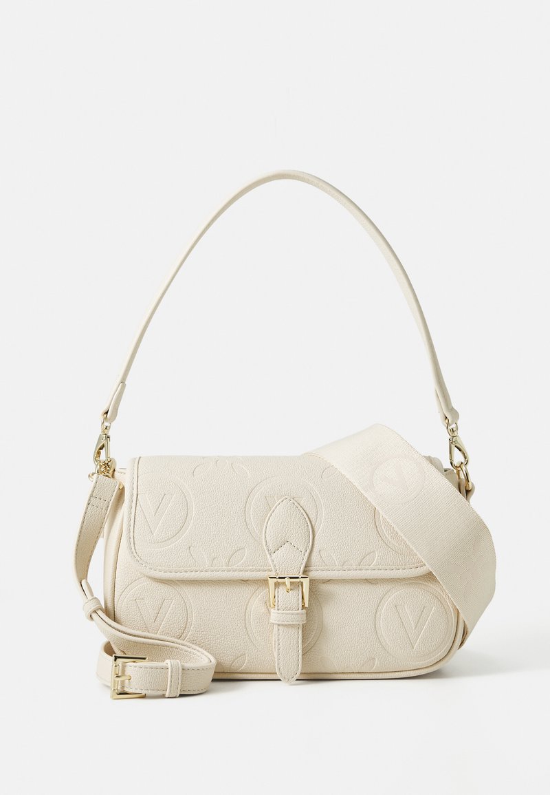 Cream-colored handbag in textured leather with embossed logo pattern, featuring a short handle and detachable shoulder strap. Gold hardware accents.