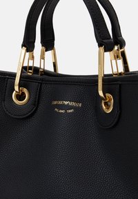 Borsa a tracolla nera in pelle con accessori dorati, con due manici superiori e una superficie testurizzata. Include logo del marchio inciso e dettagli.