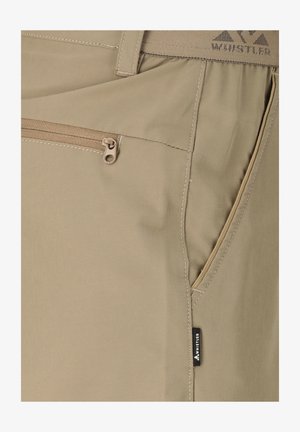 Beige broek bijna close-up met een zak met rits, zijzak met split, gedetailleerd stiksel en een klein zwart Whistler-merklabel.