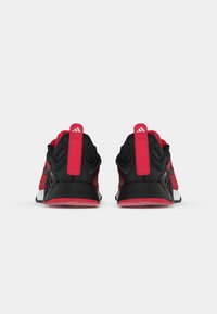 Black and red athletic shoes with a mesh upper, rubber soles, and a prominent heel loop. Features branding on the heel tab.
