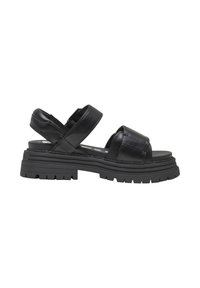 Sandales en cuir noir avec larges brides croisées, semelles compensées épaisses et profondes rainures pour une meilleure adhérence. Texture lisse avec un design minimaliste.
