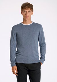 Maglione blu lavorato a maglia con maniche lunghe, scollo rotondo e orlo a coste. Presenta una texture sottile e un colletto bianco a contrasto.