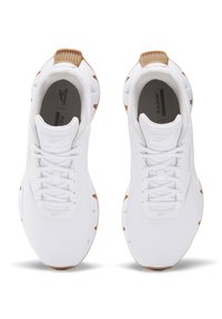 Weiße Sportschuhe mit einem Obermaterial aus Mesh, runder Schuhspitze und strukturiertem Gummisohle mit braunen Akzenten an der Ferse und den Seiten.