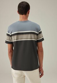 Kortærmet t-shirt med blå og grå vandrette striber. Lavet af et let materiale med en glat overflade. Klassisk rundhalset design.