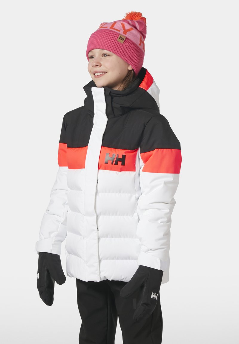 Pufová bunda s bílým tělem, černým vrškem a oranžovým pruhem, s kapucí a zipovým zapínáním. Přiložené černé rukavice a růžová pletená čepice.