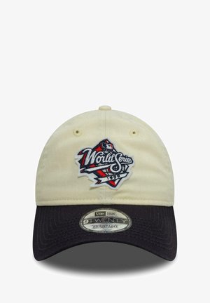 Beige Baumwollkappe mit schwarzem Schirm, auf der Vorderseite mit einem bestickten "World Series"-Logo in Rot, Weiß und Blau. Verstellbarer Riemen.