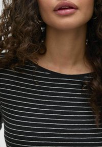 Zwart-wit gestreepte top met een ronde halslijn, voorzien van korte mouwen en een zachte, textuurvriende stof.