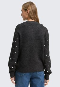 Dunkelgrauer Pullover mit strukturiertem Strick, rundem Ausschnitt und langen Ärmeln, die mit weißen Herz- und Punktmustern verziert sind.