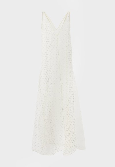 Λευκό αμάνικο φόρεμα με V-λαιμόκοψη και σχέδιο με χρυσές πουά, ρέον ύφασμα και μήκος μέχρι τον αστράγαλο.