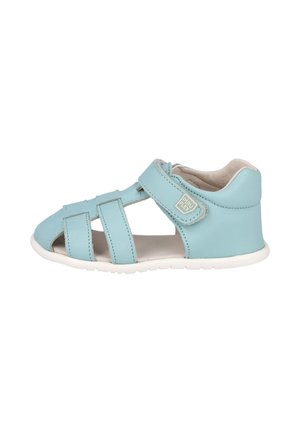 Sandalia azul clara para niño pequeño con talón cerrado, tira de velcro ajustable, puntera abierta y suela blanca flexible.