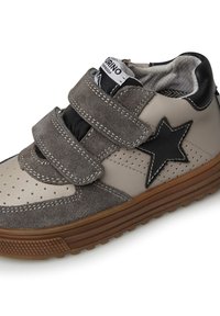 Sneaker grigie e beige con strappi in velcro, materiali in pelle e camoscio, dettaglio a stella, fori decorativi e suola in gomma testurizzata.