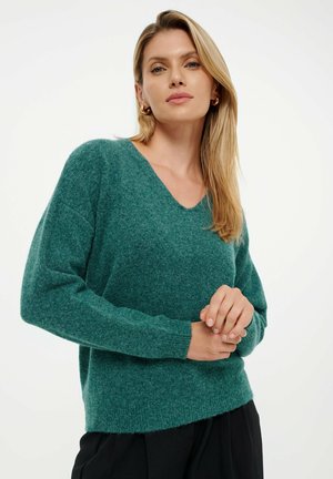 V-neck, long-sleeve sweater made of soft green material; relaxed fit and ribbed cuffs. Textured finish with a slightly oversized silhouette.
