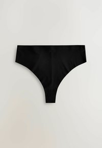 Perizoma nero realizzato in tessuto liscio, con una vita bassa e lati senza cuciture per una visibilità minima sotto i vestiti.