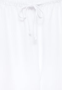 Ceinture en tissu blanc avec un cordon noué muni d'embouts en plastique à chaque extrémité.