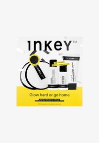 Kit fra The Inkey List inkluderer en sort og hvid rensepude, en rensemiddel, et serum og en creme på en gul baggrund med sort tekst.