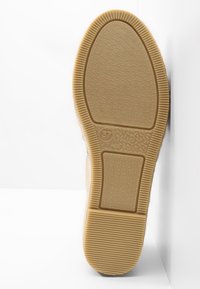 Suola di una scarpa, in gomma testurizzata di colore beige, con motivo a zigzag e logo circolare. Taglia 37, made in Spain.