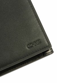 Czarny skórzany portfel o gładkiej fakturze, z delikatnym przeszyciem i wytłoczonym logo. Kompaktowy, prostokątny kształt.