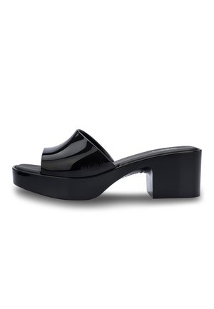 Black platform sandals with a glossy finish, featuring a wide curved strap over the foot and a block heel for stability.