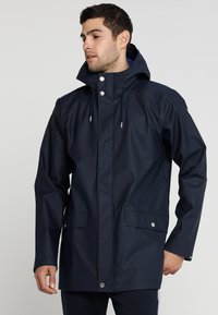 Navy waterproof jacket with a hood, two front pockets, and drawstrings. Smooth texture with snap and cord detailing.