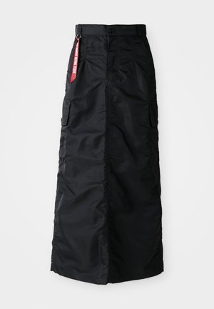 Svart lang skjørt med knapp og glidelås foran, sidelommer fra cargo-stil, og en rød "Remove Before Flight" textilplakett på midjen.