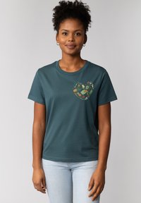 Teal katoenen t-shirt met een ronde halslijn en korte mouwen. Bevat een hartvormige graphic met verschillende natuurthema-illustraties.