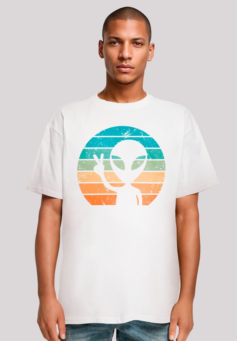 Weißes Baumwoll-T-Shirt mit einem verwaschenen Grafikdesign eines Außerirdischen und einem Friedenszeichen auf einem Farbverlaufskreis aus türkis und orangefarbenen Streifen.