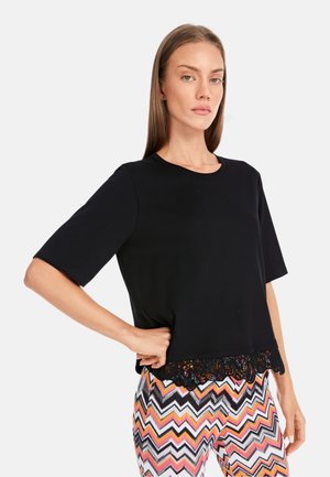 Black short-sleeve top featuring a lace hem detail. The fabric is soft with a smooth texture, providing a relaxed fit.