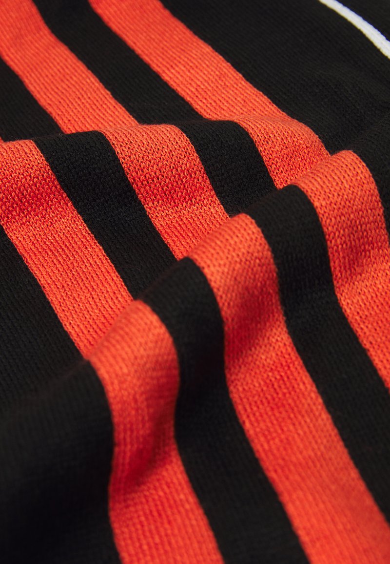 Knit textile featuring alternating bold orange and black stripes. The fabric shows a smooth texture with a slight sheen.