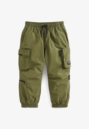 Olivgrüne Cargo-Hosen mit elastischem Bund, Kordelzug und mehreren Reißverschlusstaschen. Glatte Textur, an den Knöcheln zulaufende, breite Bündchen.